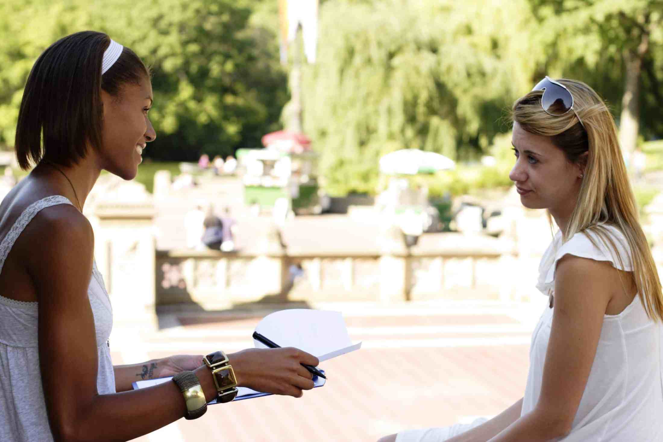 A woman interviewing another woman. Focus is on interviewer.