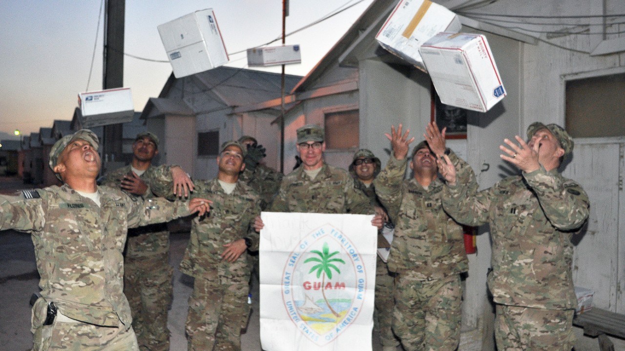 Military personnel celebrating receiving care packages