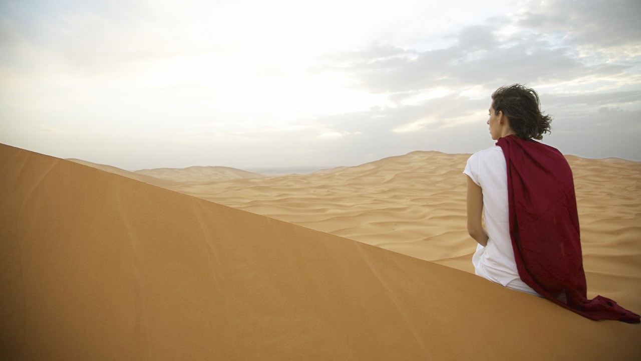 Woman Looking at Mountains in Sunset