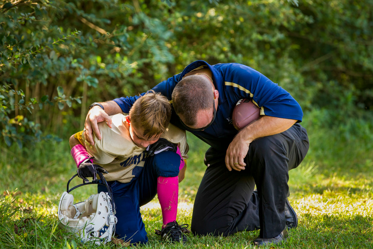 Father kneeling to pray with son