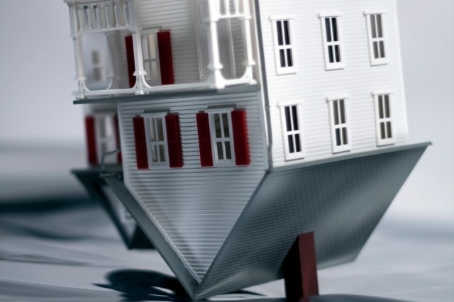 House turned upside down on reflective background.