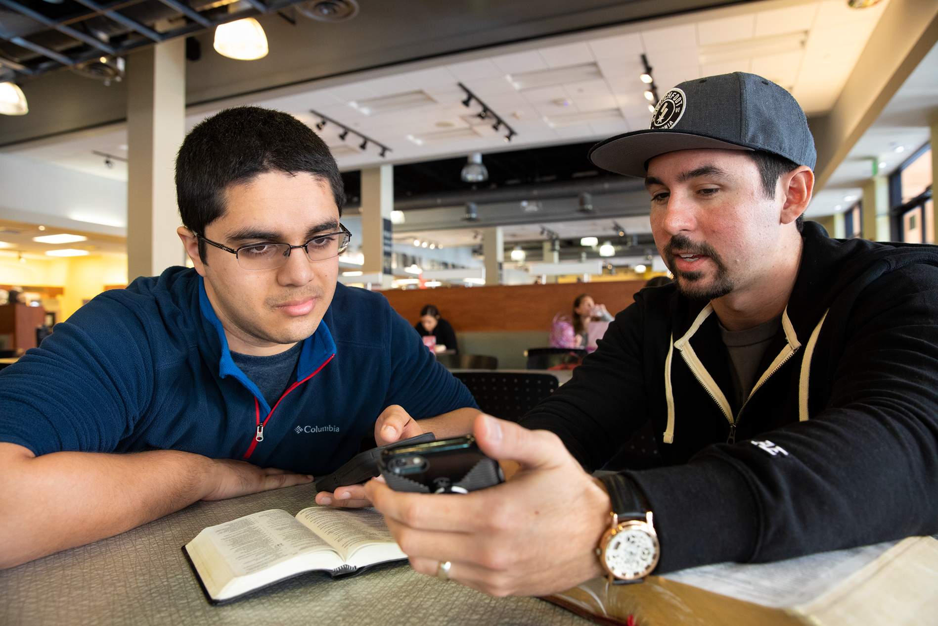 two men at table - close up of phones