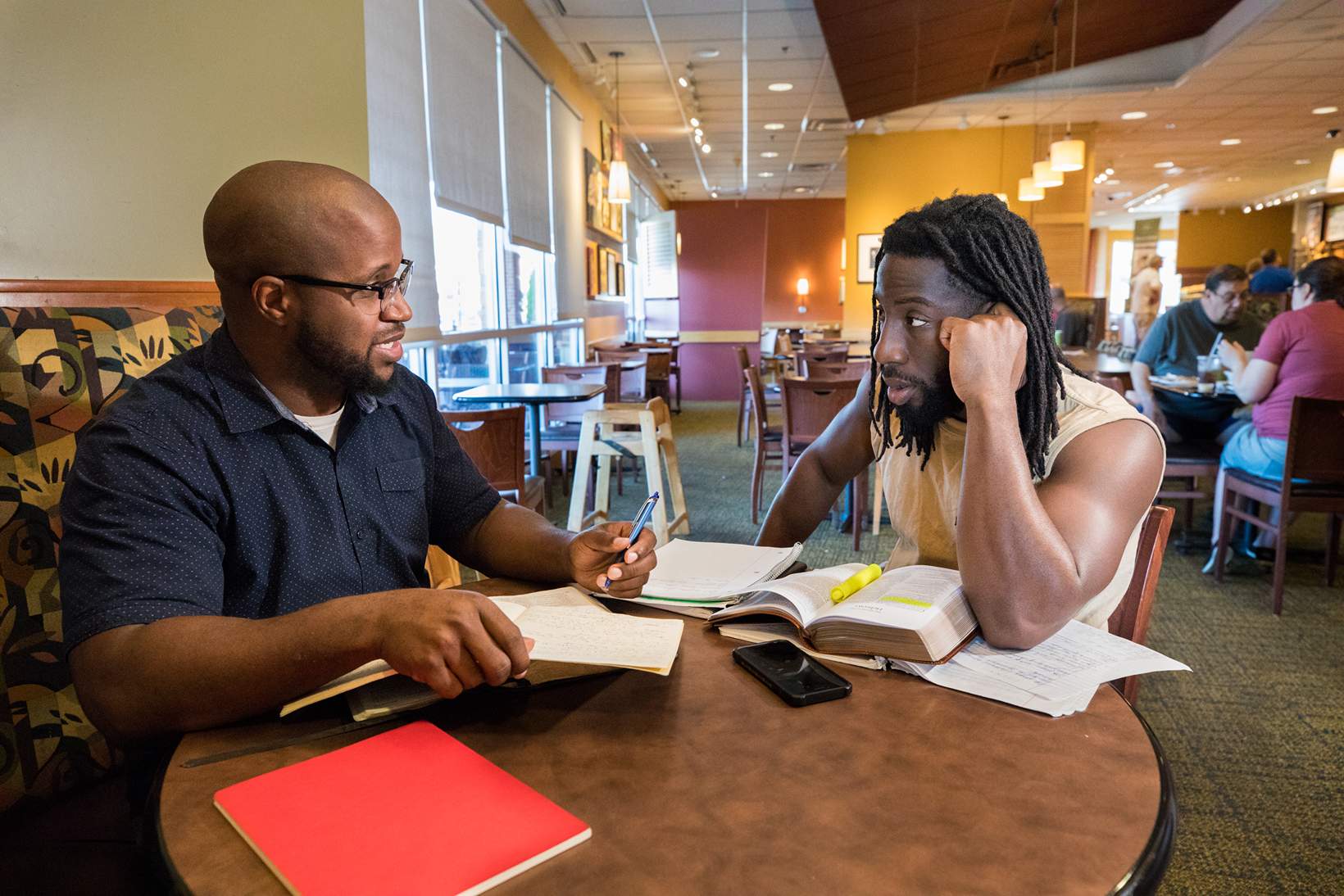 Two men at table with bibles