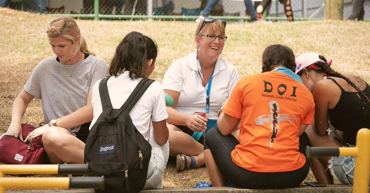 People sitting on ground and talking.