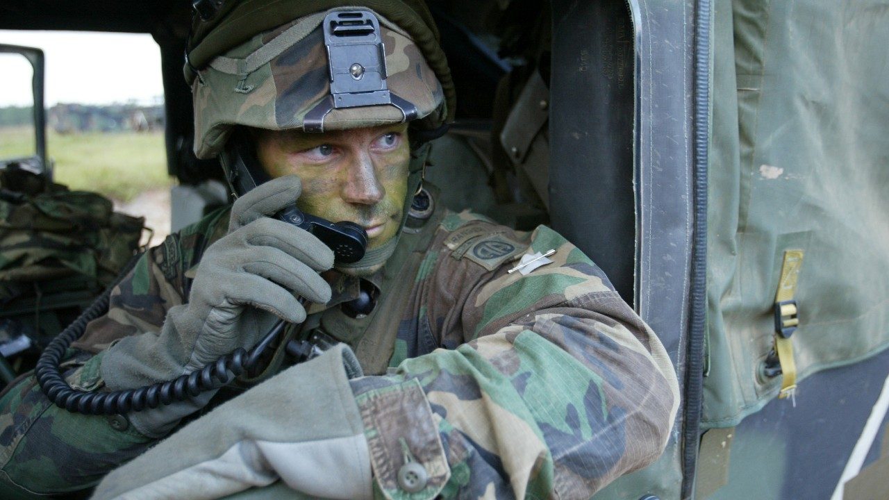 Military man in vehicle listening to radio